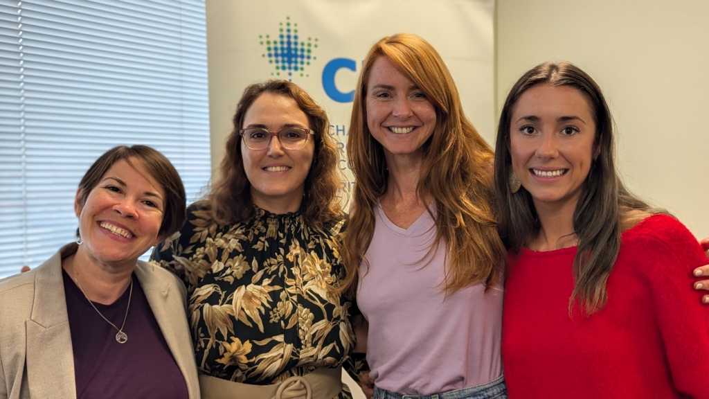 Facilitators and judges smiling after the JA Company Program summer camp pitch event, standing next to a CPA BC banner.